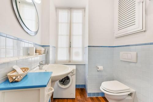 a bathroom with a toilet sink and a washing machine at La Loggia del Delfino 5 Terre Sea View AC in Lerici