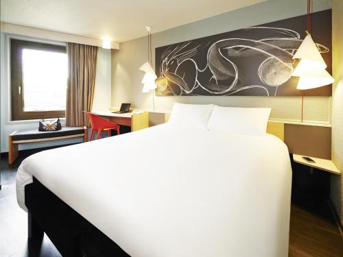 une chambre d'hôtel avec un grand lit et un bureau dans l'établissement ibis Strasbourg Centre Historique, à Strasbourg