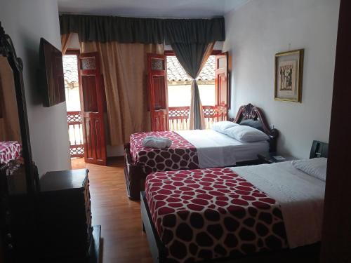 a hotel room with two beds and a window at Bonsai Hotel Salamina Caldas in Salamina