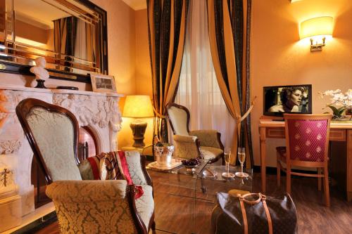 a living room with three chairs and a fireplace at Colonna Hotel in Frascati