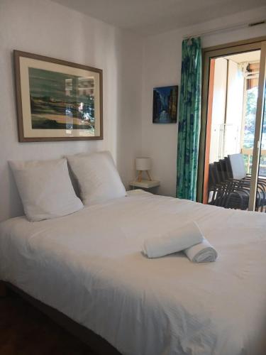 イエールにあるPied à terre - Port de Hyèresの窓のある部屋にある白いベッド