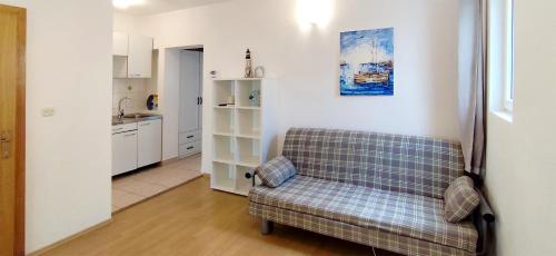 a living room with a couch and a kitchen at Apartments Martin in Drvenik