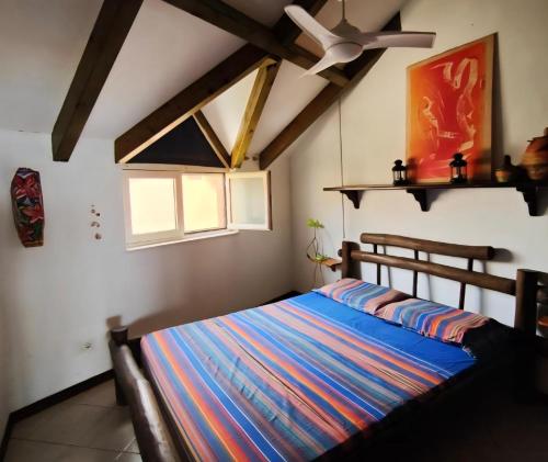 een slaapkamer met een bed en een plafondventilator bij Ibiscus Penthouse in Santa Maria