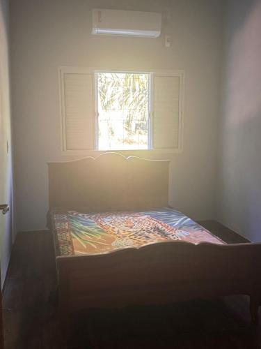 a bed in a room with a window at Rancho KurtMel in Coxim