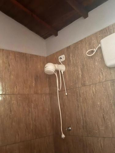 a bathroom with a blow dryer on the wall at Rancho KurtMel in Coxim