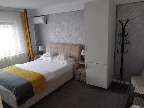 a bedroom with a large bed and a white cabinet at Garsoniere in Târgu Jiu