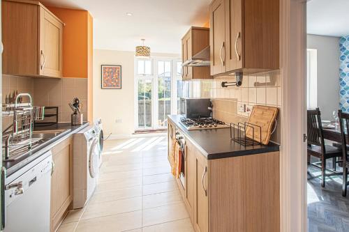 a kitchen with wooden cabinets and a stove top oven at Large Central Townhse 2Baths FREE parking Superking bed in Canterbury