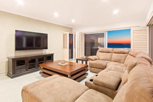 a living room with a couch and a flat screen tv at Tenos On Calypso 12 in Langebaan