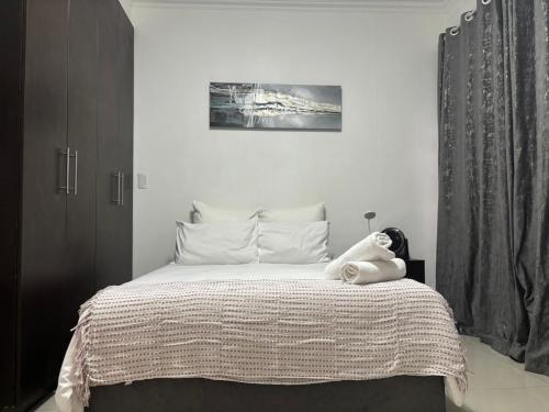 a bedroom with a bed with a stuffed animal on it at Urban Park K001, Umhlanga Rocks in Durban