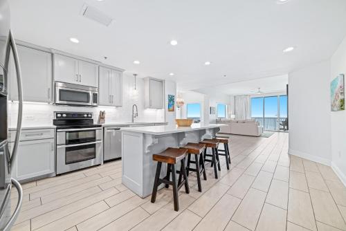 una cucina con mobili bianchi e sgabelli da bar di Spanish Key Unit 301 a Perdido Key