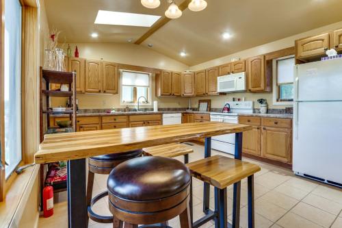 a kitchen with wooden cabinets and a large island with bar stools at Deep Creek Lake Townhome with Deck and Water Views in Oakland
