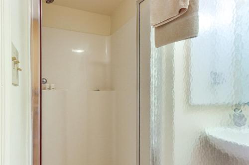 a shower with a glass door next to a sink at Deep Creek Lake Townhome with Deck and Water Views in Oakland