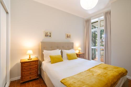 a bedroom with a bed with two lamps and a window at Casa Branca Apartments by Wanderlust Madeira, vacation rentals in Funchal