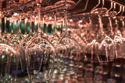 a bunch of wine glasses hanging from a rack at Pensjonat Retro in Łomża