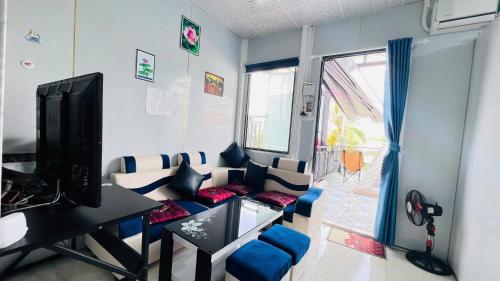 Ấp Ông TúにあるHOMESTAY Hoàng GIaのソファとテレビのあるリビングルーム