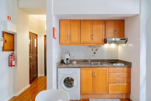 a kitchen with a sink and a washing machine at Casa Branca Apartments by Wanderlust Madeira, vacation rentals in Funchal