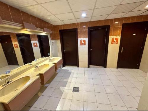 La salle de bains est pourvue d'une rangée de lavabos et de miroirs. dans l'établissement فندق الزائر الأخيار الفندقية, à La Mecque