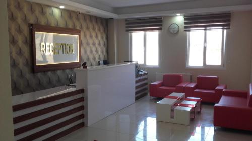 a waiting room with red chairs and a reception desk at Gunes Hotel in Hacıbektaş