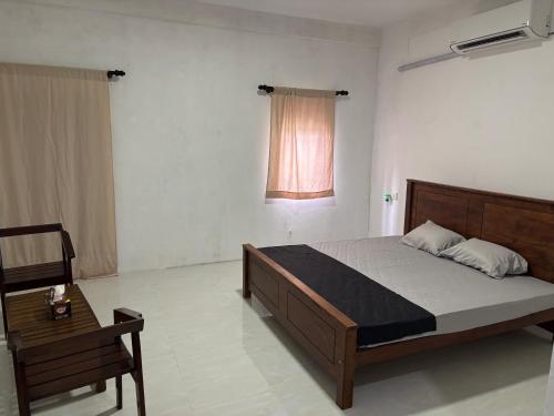 a bedroom with a bed and a chair and a window at Mapa Group Rest House in Kurunegala
