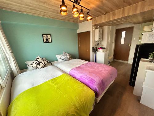a bedroom with a large yellow and white bed at テラ二十四軒 in Sapporo