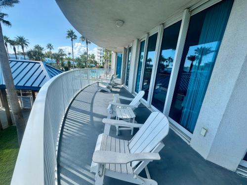 una fila di panche bianche sedute su un balcone di A Dose of Vitamin Sea a Destin