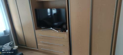 a television sitting on top of a wooden dresser at Ratusz Wroclaw in Wrocław