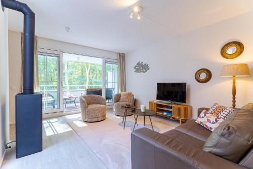 a living room with a couch and a fireplace at Duinhof Klein Dishoek - Appartementen onder aan de duinen, in het centrum met terras in Dishoek