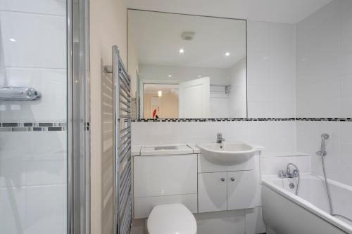 a bathroom with a sink and a toilet and a tub at Large Central Townhse 2Baths FREE parking Superking bed in Canterbury