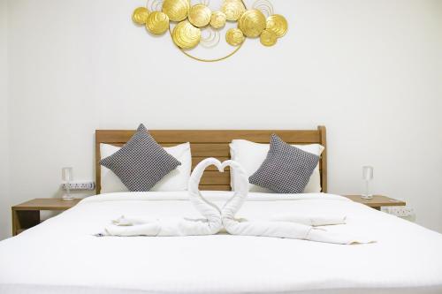 a bedroom with a bed with two white towels at Marina Retreat Stylish One Bedroom by Hala Homes in Ras al Khaimah