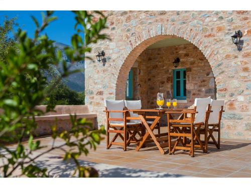 a wooden table and chairs on a patio at Pandora in Pirgos Dhirou