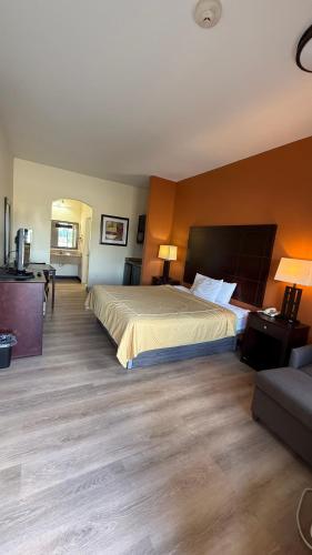 a hotel room with a large bed and a couch at Executive Inn and Suites in Pittsburg