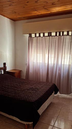 un dormitorio con una cama y una ventana en Bella Casa La Costa, en Santa Teresita