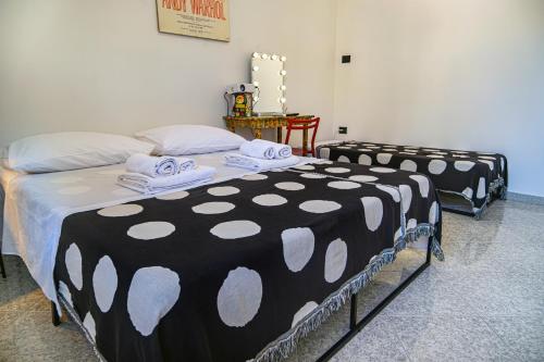 Dos camas en una habitación con sábanas blancas y negras. en Ziettas Pop House, en Nápoles