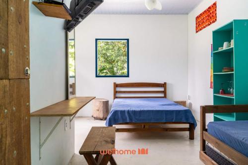 une chambre avec un lit, une table et une fenêtre dans l'établissement Kitnet em Aldeia Velha com piscina e churrasqueira, à Aldeia Velha