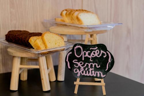 une table avec deux plateaux de pain et un tableau noir dans l'établissement Mercure Sao Paulo Pamplona, à São Paulo