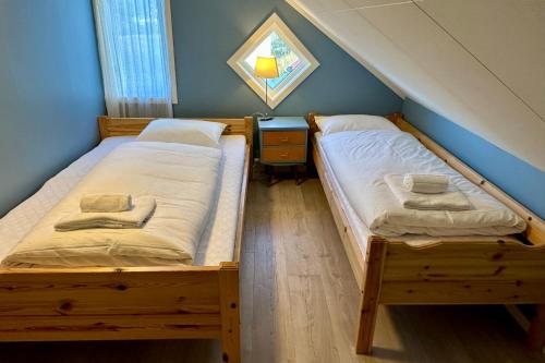 BøstadにあるCalm Hideaway Vestresandの青い壁の客室で、ツインベッド2台が備わります。