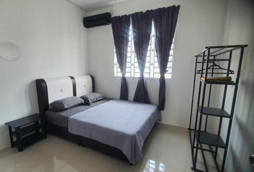 a small bedroom with a bed and a window at Aristar D'Sejahtera Homestay 4 mu5lim in Bandar  Pusat Jengka