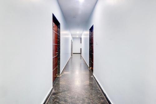 an empty corridor with white walls and a long hallway at Hotel O Moon light in Nizāmābād