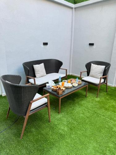 patio z 2 krzesłami i stołem z jedzeniem w obiekcie Residance touristique marcadal by mon rêve w mieście Fort de lʼEau