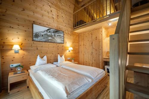 Un dormitorio con una cama en una cabaña de madera. en Mayr Natur Apartments, en Santa Cristina Valgardena