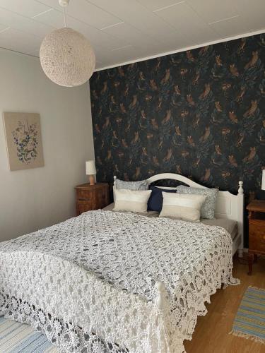 a bedroom with a white bed with a black wall at Ådalsvägenhus in Fågelfors