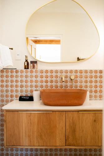 a bathroom with a wooden sink and a mirror at Sunset Stays Lavender Cottage in Cape Town
