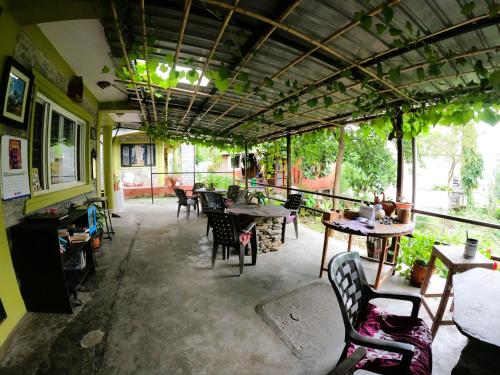 NG Resthouse في Pokhara: مطعم به طاولات وكراسي في غرفة
