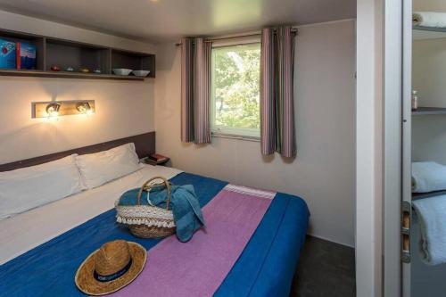 a bedroom with a bed with a hat on it at Camping Le Chêne Gris in Pommeuse