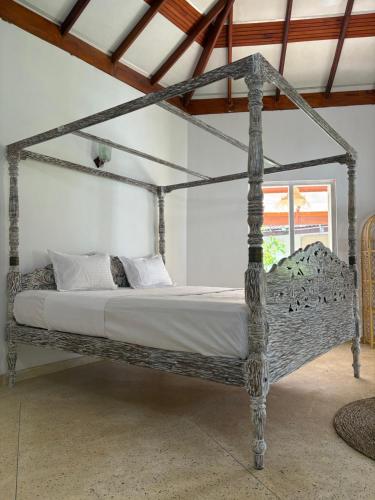 Un dormitorio con una cama con dosel en una habitación. en Paradise Bungalow, en Weligama