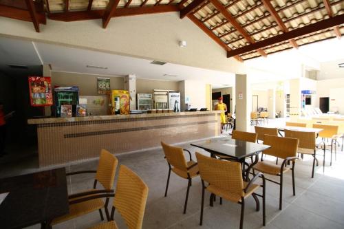a restaurant with tables and chairs and a counter at Boulevard Suite in Caldas Novas