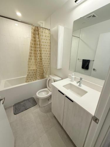 une salle de bain blanche avec toilettes et lavabo dans l'établissement Executive Condo in Prime Erin Mills Location l Walk to Mall and Hospital, à Mississauga