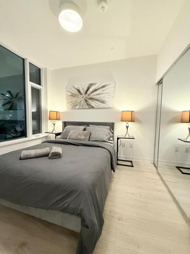 une chambre avec un grand lit et deux lampes dans l'établissement Executive Condo in Prime Erin Mills Location l Walk to Mall and Hospital, à Mississauga