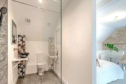 リンカーンにある1 Bed Barn Retreat - Fireplace Patio Parkingのベッドルームにつながるガラスドア付きのバスルーム