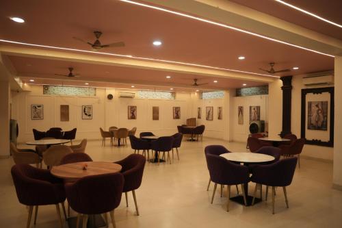 a restaurant with tables and chairs and pictures on the walls at Virasat Vistar Gateway in Lucknow